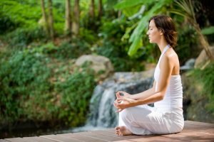 A young woman practising yoga outside in nature